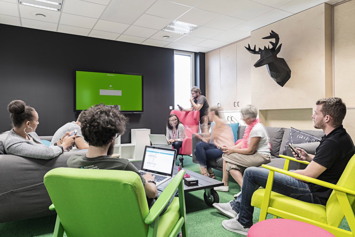 équipe réunie dans un espace de travail collaboratif moderne et coloré avec mobilier design