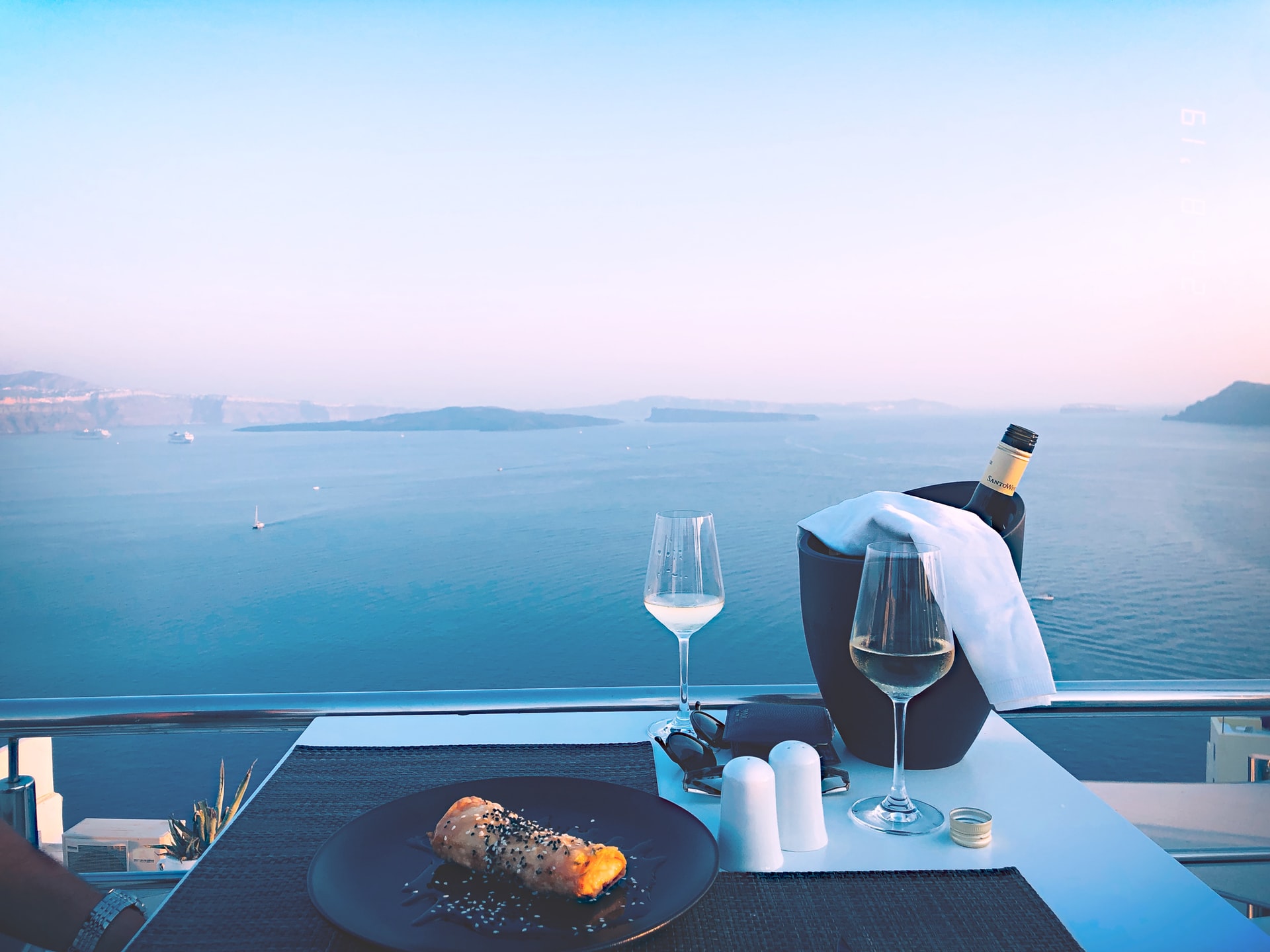 vue panoramique d'une table avec verres de vin blanc et assiette face à la mer méditerranée