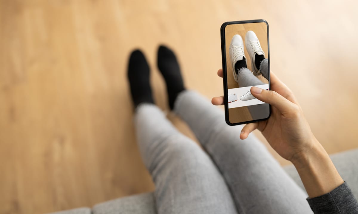 personne photographiant ses chaussures blanches avec son téléphone pour un essayage virtuel