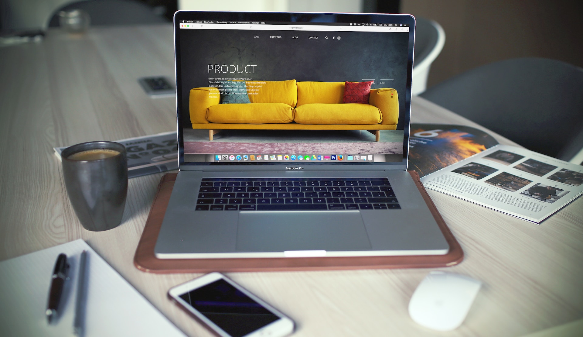 macbook pro affichant un site portfolio de designer graphiste avec canapé jaune