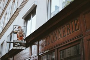 Wooden storefront with "gardonnerie" sign and vintage advertisement.