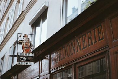 Wooden storefront with "gardonnerie" sign and vintage advertisement.